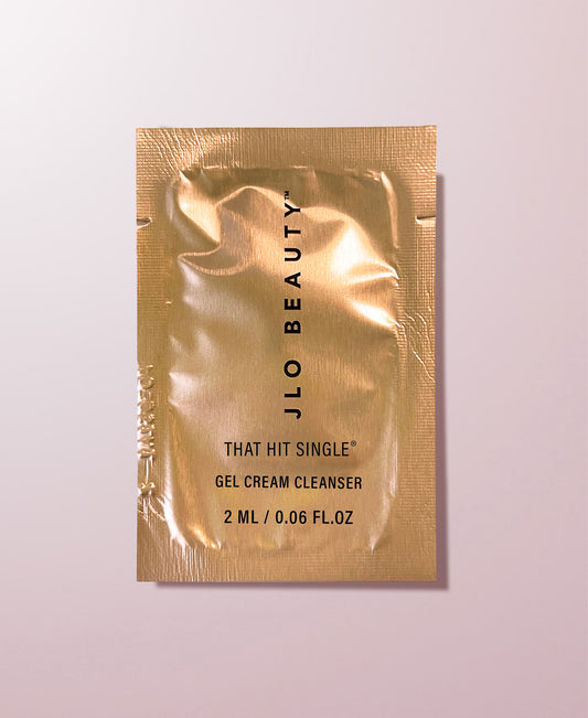 JLO Beauty gel cream cleanser sample packet on a light pink background