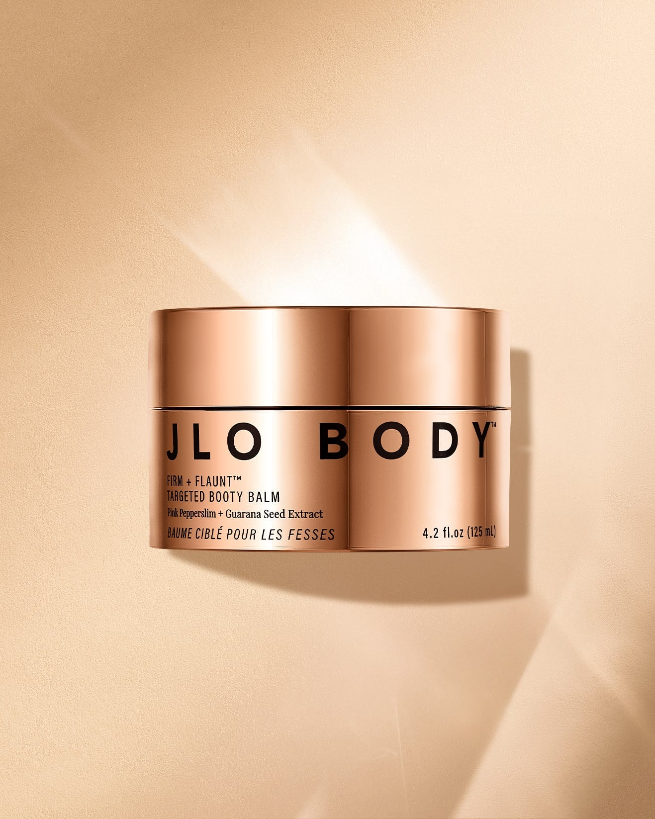 JLO Beauty Firm +Flaunt Booty Balm gold jar image on a gold background